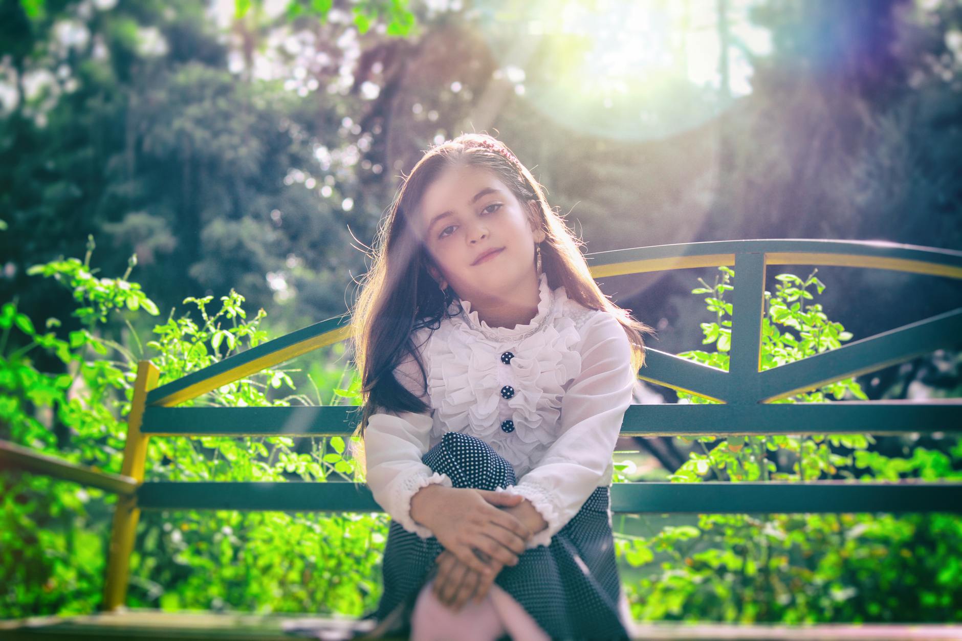 girl sitting on bench near plants